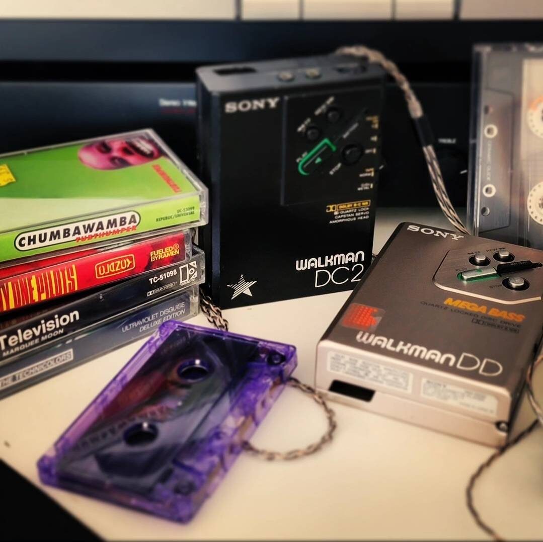 Sony Walkman DC2 and WALKMAN DD players with a stack of cassettes